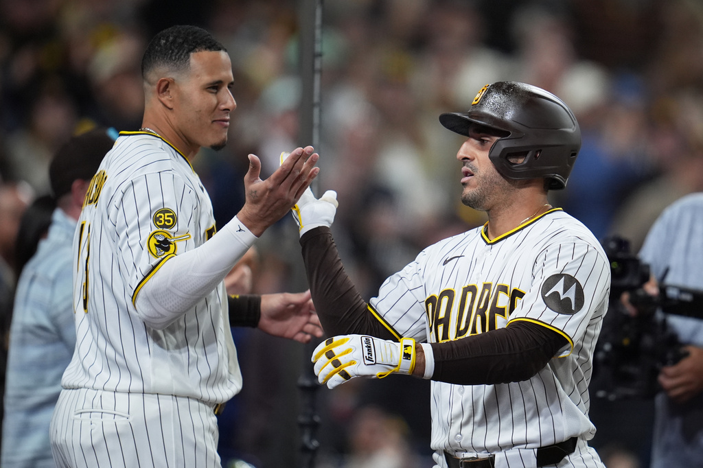 San Diego Padres' Ramón Laureano, right, celebrates with teamate Manny Machado after hitting a home run during the eighth inning of a baseball game against the Philadelphia Phillies Tuesday, May 26, 2026, in San Diego. (AP Photo/Gregory Bull)