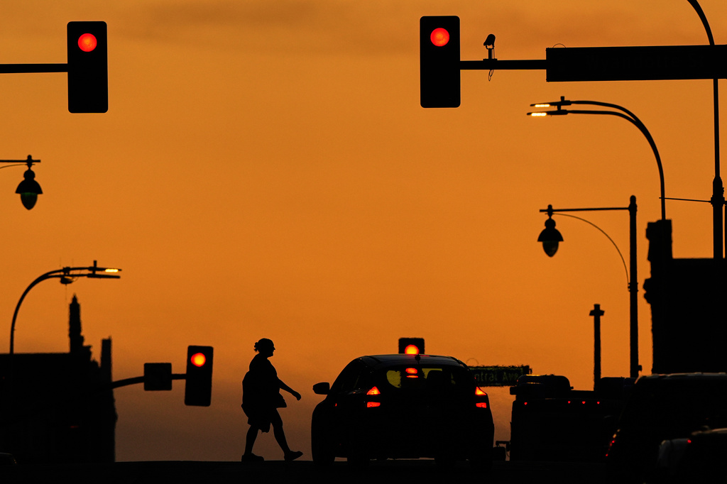 FILE - A person crosses a downtown street as the sun sets, March 31, 2025, in Kansas City, Mo. (AP Photo/Charlie Riedel, file)