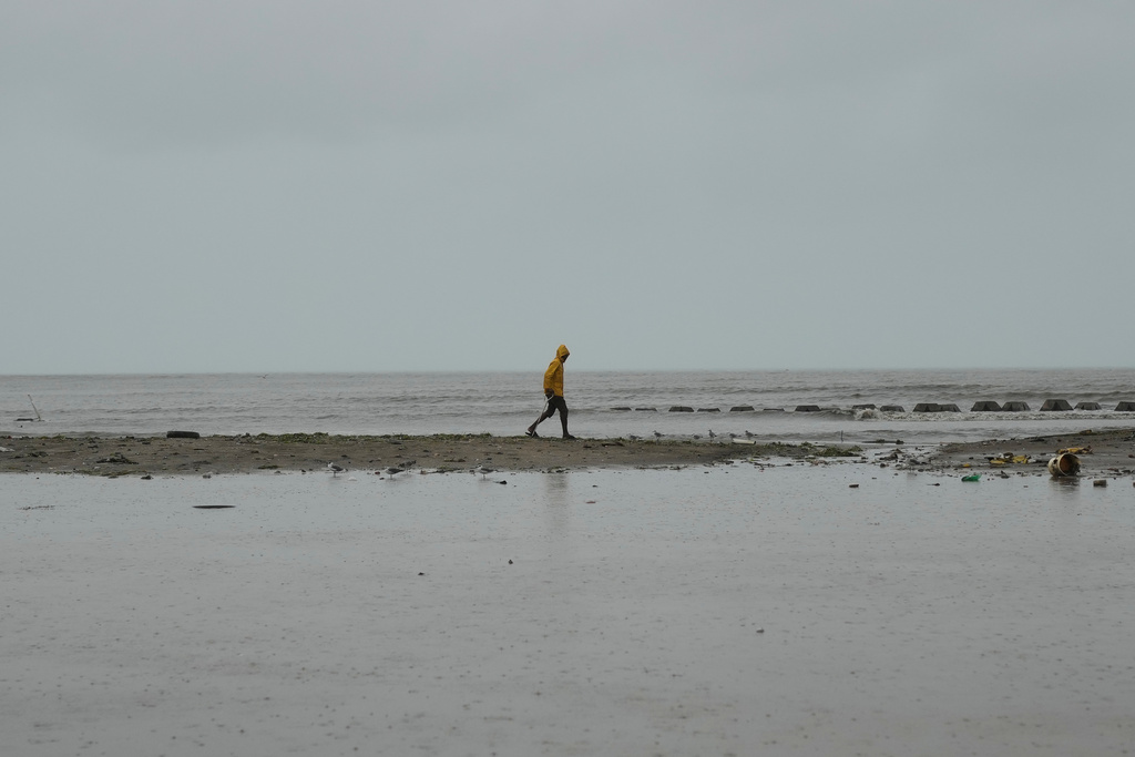 A man walks along the coastline ahead of the forecasted arrival of Hurricane Melissa in Old Harbour, Jamaica, Monday, Oct. 27, 2025. (AP Photo/Matias Delacroix)