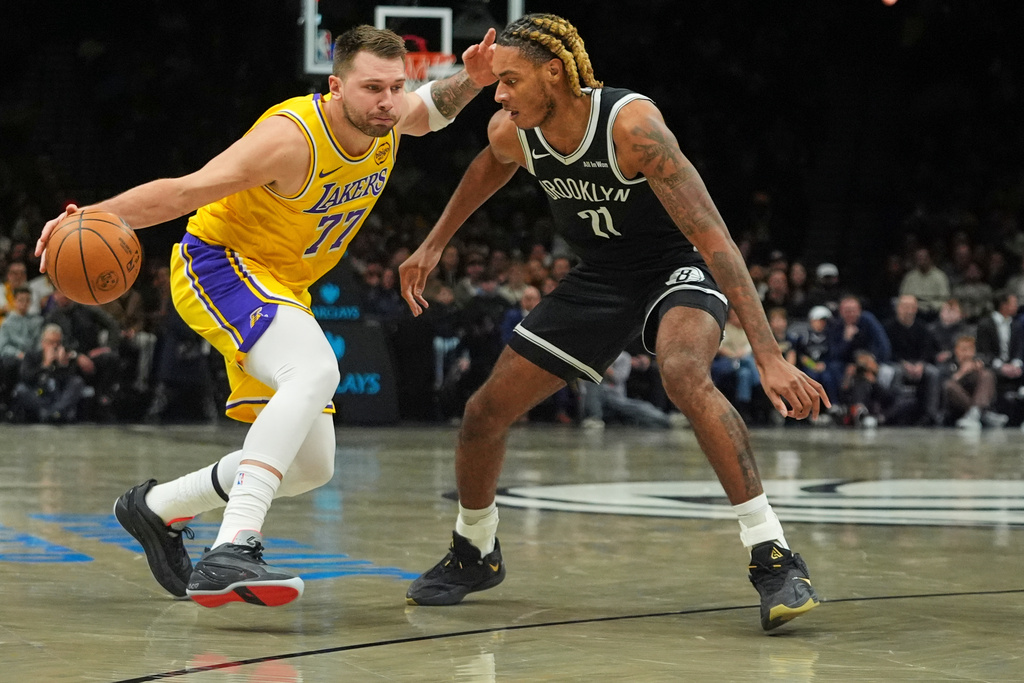 Brooklyn Nets' Noah Clowney, right, defends Los Angeles Lakers' Luka Dončić (77) during the first half of an NBA basketball game Tuesday, Feb. 3, 2026, in New York. (AP Photo/Frank Franklin II)