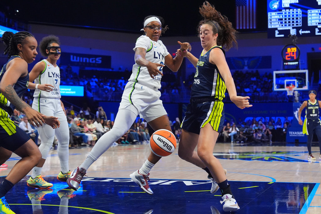 Dallas Wings forward Maddy Siegrist, front right, and Minnesota Lynx forward Liatu King (2) look at the ball during the first half of a WNBA basketball game in Arlington, Texas, Sunday, June 28, 2026. (AP Photo/LM Otero)