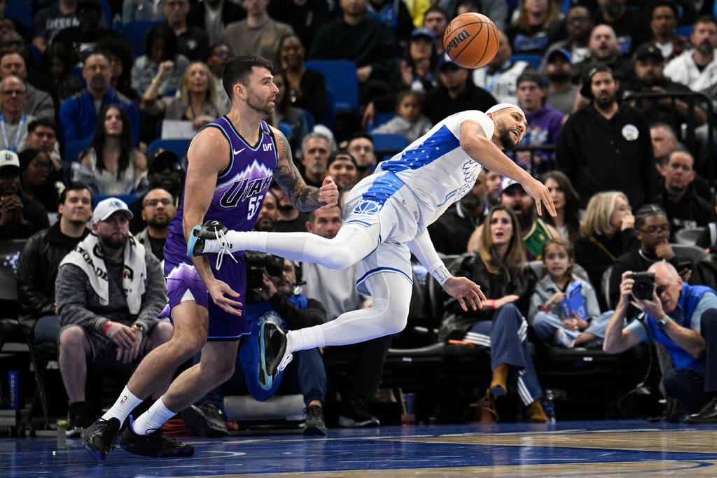 Orlando Magic guard Jalen Suggs (4) loses control of the ball as Utah Jazz forward John Konchar (55) defends during the first half of an NBA basketball game, Saturday, Feb. 7, 2026, in Orlando, Fla. (AP Photo/Phelan M. Ebenhack)