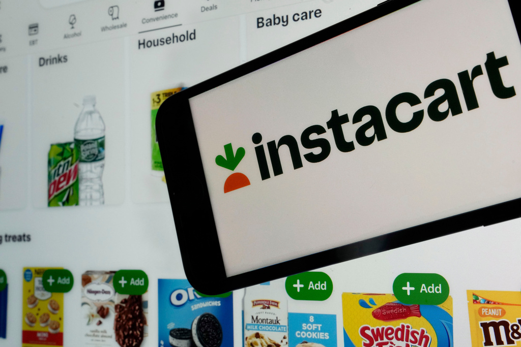 FILE - An instacart logo and an instacart webpage are shown in this photo, in New York, on Sept. 6, 2023. (AP Photo/Richard Drew, File)