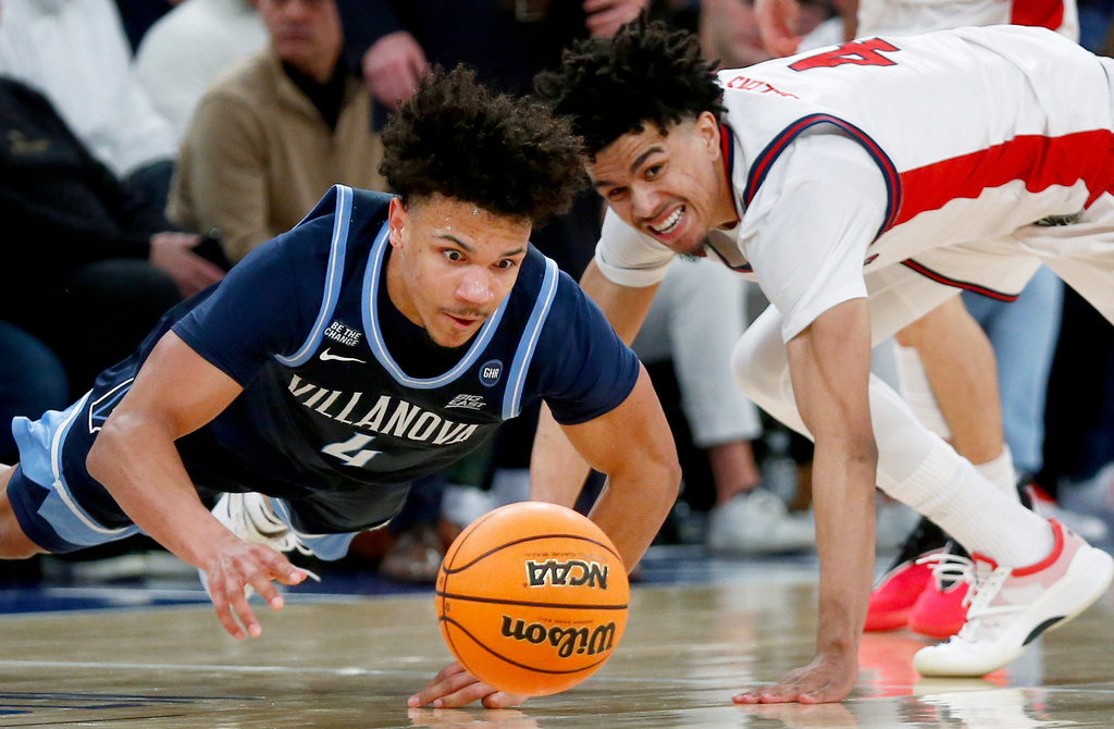 Villanova guard Tyler Perkins, left, and St. John's guard Oziyah Sellers dive for a loose ball during the second half of an NCAA college basketball game Saturday, Feb. 28, 2026, in New York. (AP Photo/John Munson)