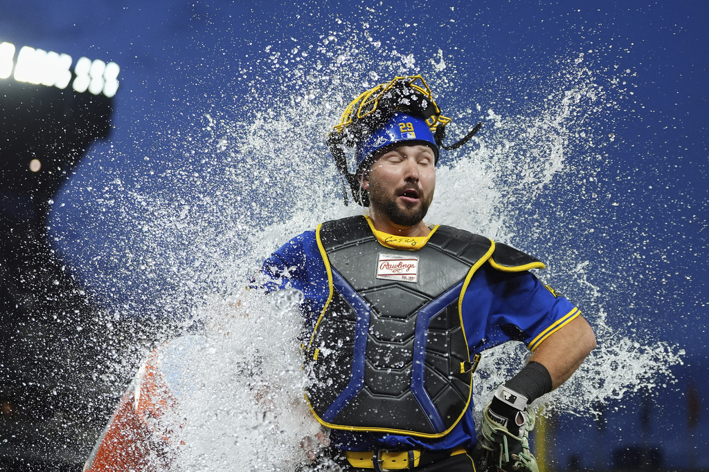 Seattle Mariners catcher Cal Raleigh reacts to being doused by teammate Victor Robles to celebrate his three-run home run after a win against the Tampa Bay Rays in a baseball game Friday, Aug. 8, 2025, in Seattle. (AP Photo/Lindsey Wasson)
