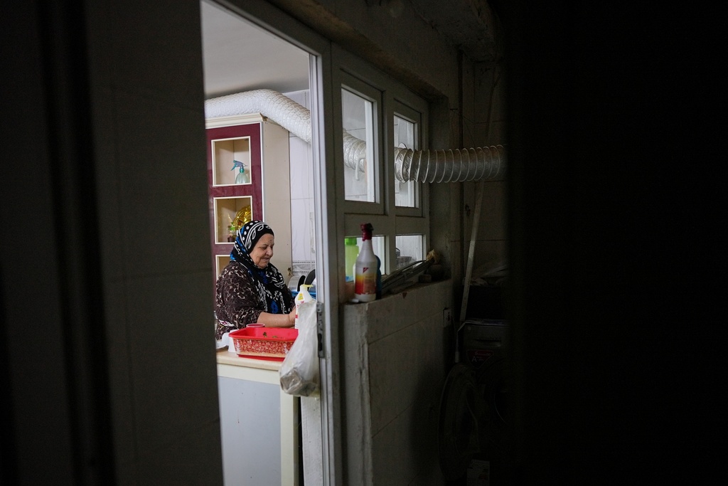 Syrian refugee Hayat Fatah, 65, cleans dishes at her home in Irbil, Iraq, Nov. 16, 2025. (AP Photo/Farid Abdulwahed)