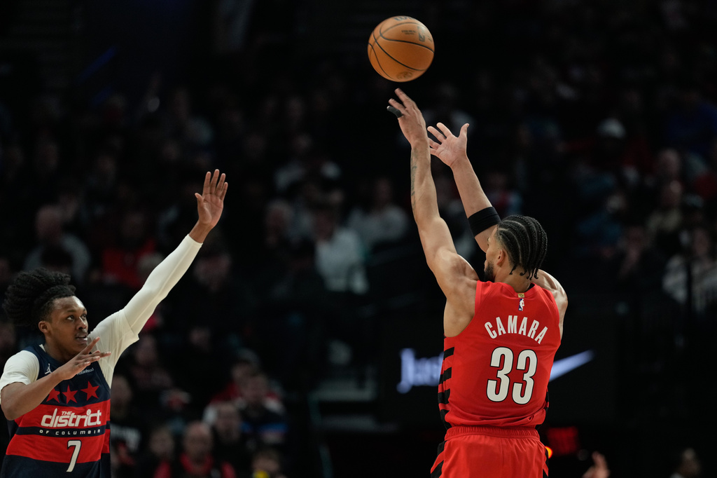Portland Trail Blazers forward Toumani Camara (33) shoots a 3-pointer over Washington Wizards guard Bub Carrington (7) during the first half of an NBA basketball game Sunday, March 29, 2026, in Portland, Ore. (AP Photo/Jenny Kane)