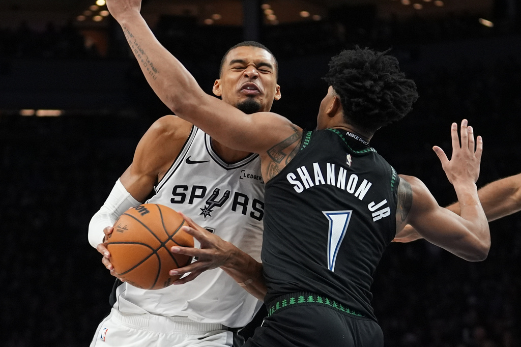 San Antonio Spurs forward Victor Wembanyama, left, is fouled by Minnesota Timberwolves guard Terrence Shannon Jr. (1) as he drives to the basket during the second half of Game 3 of a NBA basketball second-round playoff series in Minneapolis, Friday, May 8, 2026. (AP Photo/Abbie Parr)