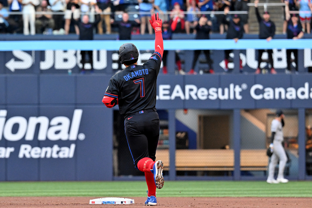 Toronto Blue Jays infielder Kazuma Okamoto (7) gestures to the bullpen after hitting a two-run home run scoring Alejandro Kirk, not pictured, against the New York Yankees during first inning of a baseball game in Toronto on Friday, June 12, 2026. (Jon Blacker/The Canadian Press via AP)