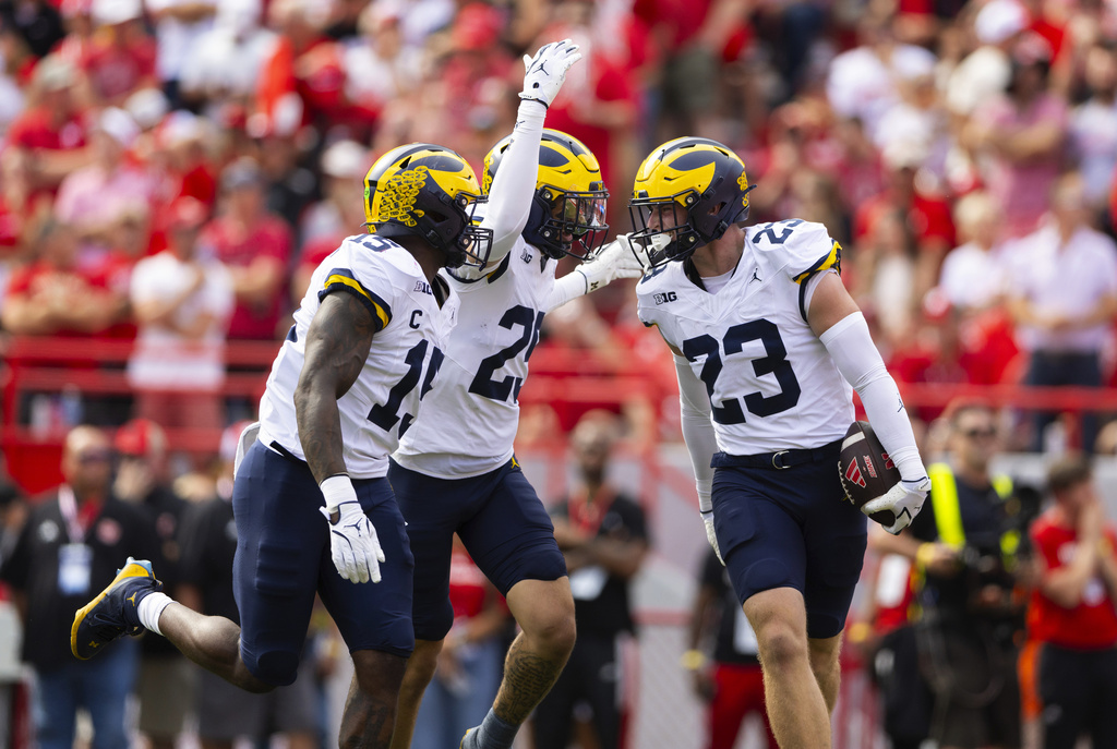 Michigan's Cole Sullivan (23) celebrates an interception alongside Ernest Hausmann (15) and Mason Curtis (25) during the first half of an NCAA college football game against Nebraska, Saturday, Sept. 20, 2025, in Lincoln, Neb. (AP Photo/Rebecca S. Gratz)