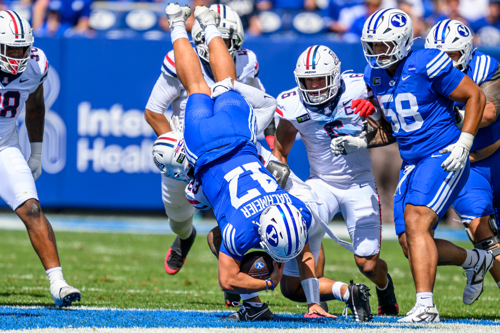 BYU quarterback Bear Bachmeier (47) runs the ball and gets upended from a tackle during the first half an NCAA college football game against Arizona, Saturday, Sept. 12, 2026, in Provo, Utah. (AP Photo/Tyler Tate)