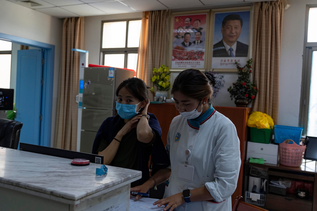 Nurses at their station near a portrait of Chinese President Xi Jinping at the Xizang Autonomous Region Hospital of Tibetan Medicine in Lhasa, in western China's Tibet Autonomous Region on Wednesday, July 22, 2026 as seen during a government organized visit for foreign journalists. (AP Photo/Ng Han Guan)