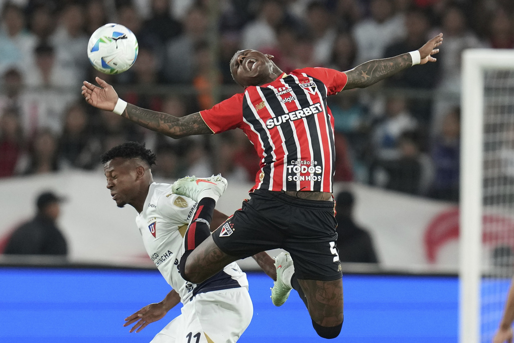 Robert Arboleda of Brazil's Sao Paulo, right, and Michael Estrada of Ecuador's Liga Deportiva Universitaria battle for the ball during a Copa Libertadores quarterfinal first leg soccer match at Rodrigo Paz Delgado stadium in Quito, Ecuador, Thursday, Sept. 18, 2025. (AP Photo/Dolores Ochoa)