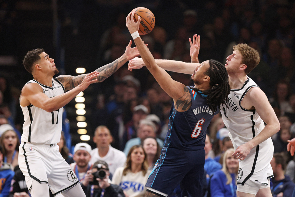 Brooklyn Nets forward Michael Porter Jr., left, Nets forward Danny Wolf, right, and Oklahoma City Thunder forward Jaylin Williams (6) try to grab a rebound during the first half of an NBA basketball game Friday, Feb. 20, 2026, in Oklahoma City. (AP Photo/Nate Billings)