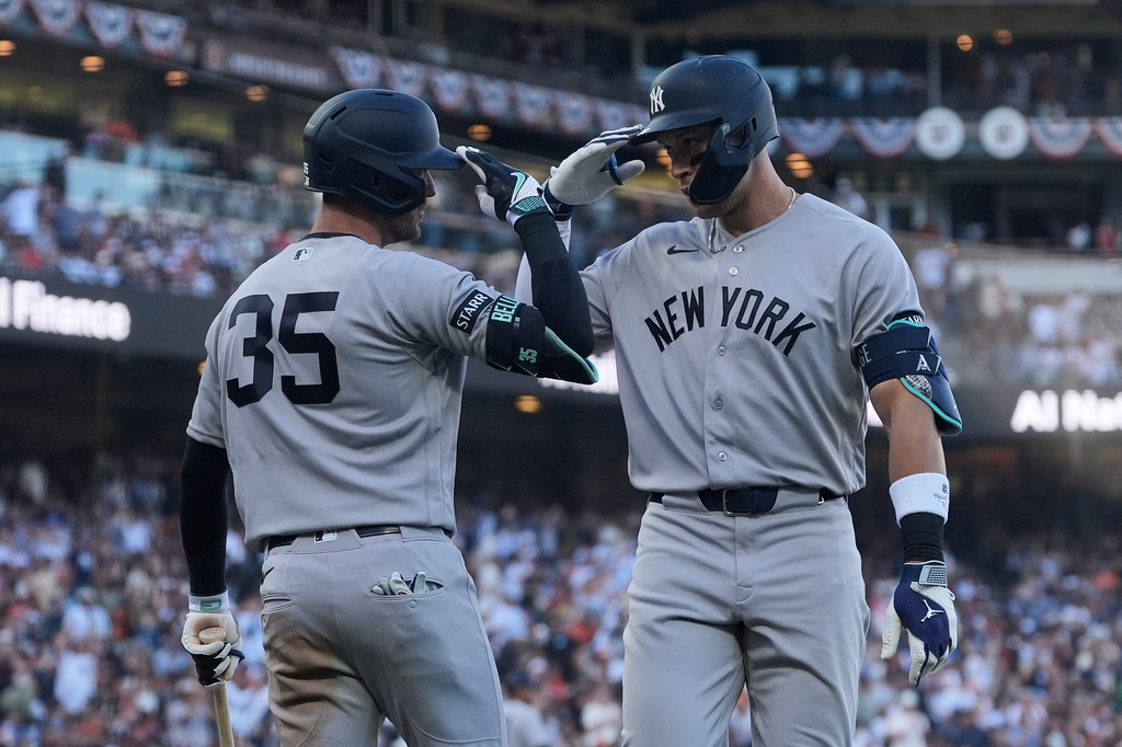 New York Yankees' Aaron Judge, right, is congratulated by Cody Bellinger (35) after hitting a home run against the San Francisco Giants during the fifth inning of a baseball game in San Francisco, Saturday, March 28, 2026. (AP Photo/Jeff Chiu)