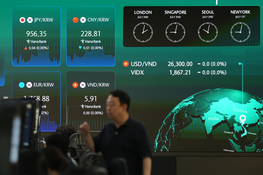 A dealer walks past near the screens showing the foreign exchange rates at a dealing room of Hana Bank in Seoul, South Korea, Thursday, July 2, 2026. (AP Photo/Lee Jin-man)