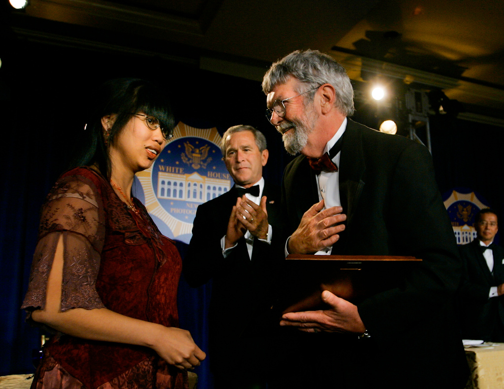 FILE - Photojournalist Chick Harrity, right, reunites with Nhanny Heil, an orphan he photographed as an abandoned baby sleeping in a box on a street during the Vietnam War, as President George W. Bush, center, looks on during the White House News Photographers’ Association “Eyes of History 2005 Gala” in Washington, Saturday, May 21, 2005. (AP Photo/J. Scott Applewhite)