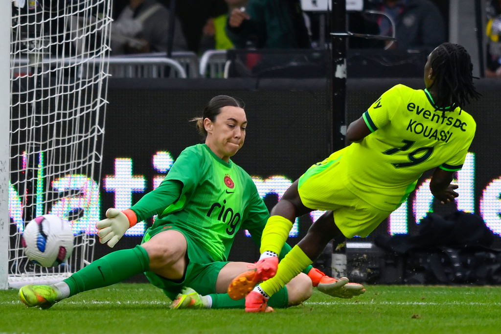 Washington Spirit forward Rosemonde Kouassi (19) plays the ball past Portland Thorns FC goalkeeper Mackenzie Arnold where teammate Gift Monday scored a goal during the first half of a NWSL semifinal women's soccer match, Saturday, Nov. 15, 2025, in Washington. (AP Photo/John McDonnell)
