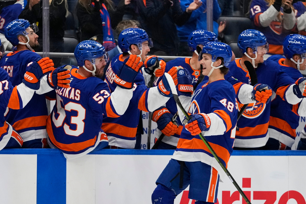 New York Islanders' Matthew Schaefer (48) celebrates with teammates after scoring his first NHL goal during the third period of an NHL hockey game against the Washington Capitals Saturday, Oct. 11, 2025, in Elmont, N.Y. (AP Photo/Frank Franklin II)