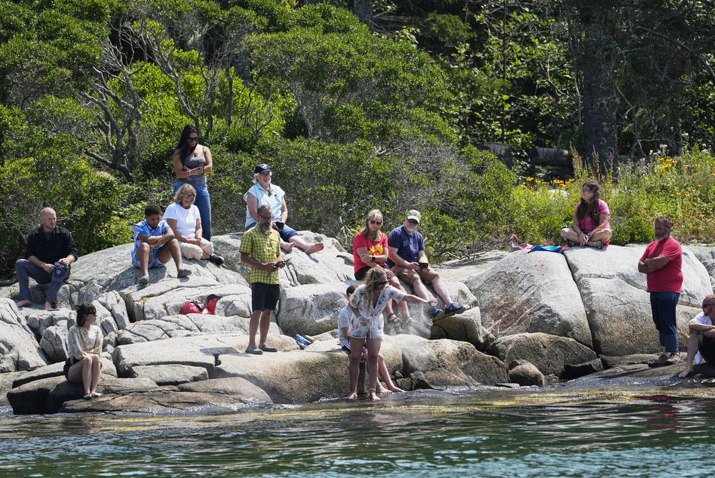 Kim Ware, of Somerville, Mass., spreads the ashes of her sister, Sunshine Stewart, on High Island during a memorial service, Sunday, Aug. 10, 2025, off the coast of St. George, Maine. (AP Photo/Robert F. Bukaty)