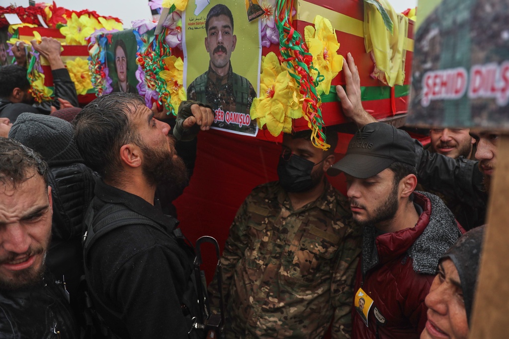 Soldiers carry coffins during the funeral of Kurdish-led Syrian Democratic Forces (SDF) fighters killed earlier this month during clashes with Syrian government forces, in Qamishli, northeastern Syria, Wednesday, Jan. 28, 2026. (AP Photo/Baderkhan Ahmad)