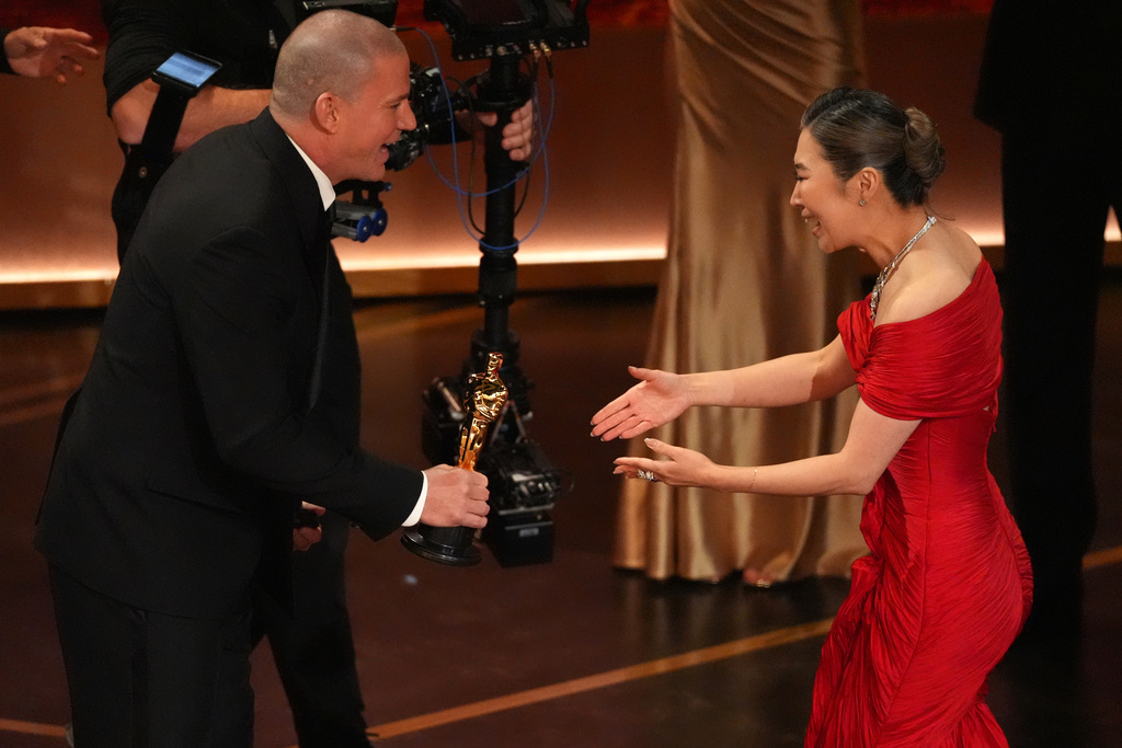 Channing Tatum, left, presents the award for best animated feature film to Maggie Kang for "K-pop Demon Hunters"during the Oscars on Sunday, March 15, 2026, at the Dolby Theatre in Los Angeles. (AP Photo/Chris Pizzello)