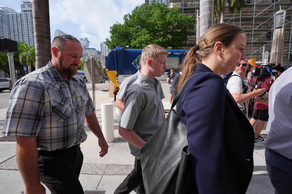 Timothy Hudson, center, charged with sexually assaulting and killing his 18-year-old stepsister on a Carnival Cruise ship, arrives for a hearing at the The James Lawrence King Federal Justice Building, Wednesday, May 27, 2026, in Miami. (AP Photo/Rebecca Blackwell)