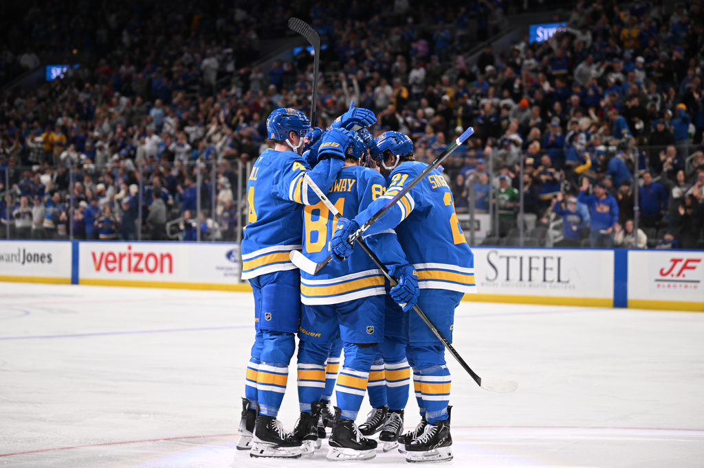 St. Louis Blues' Jimmy Snuggerud (21) celebrates with teammates after scoring a goal against the Toronto Maple Leafs' during the second period of an NHL hockey game Saturday, March 28, 2026, in St. Louis. (AP Photo/Connor Hamilton)