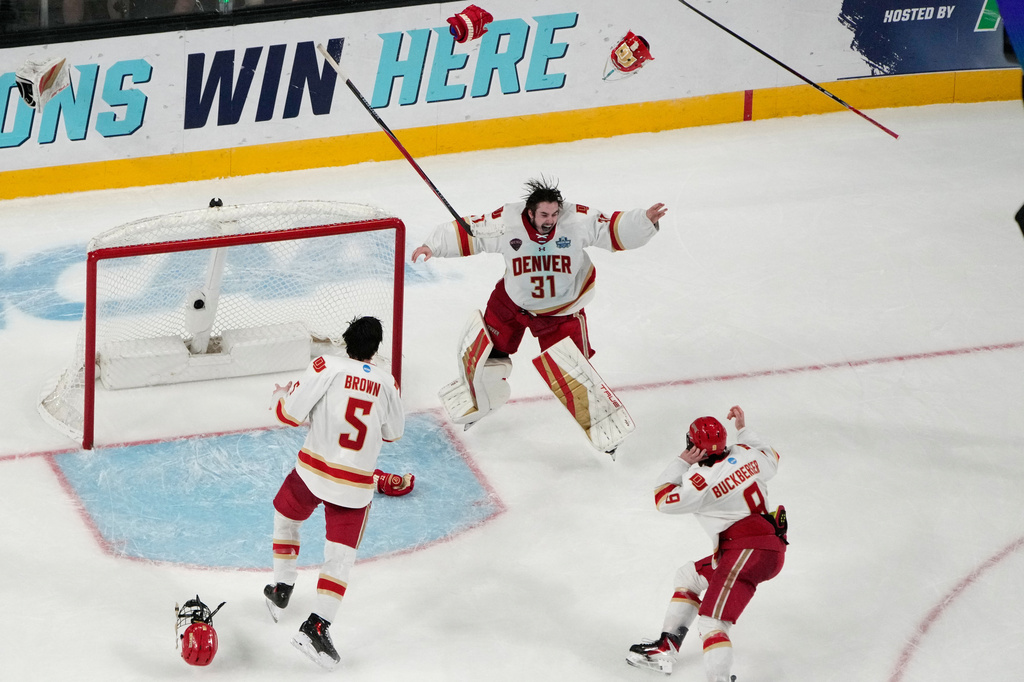 Denver goaltender Johnny Hicks (31) celebrates with teammates after defeating Wisconsin in the championship game at the NCAA Frozen Four men's college hockey tournament Saturday, April 11, 2026, in Las Vegas. (AP Photo/John Locher)