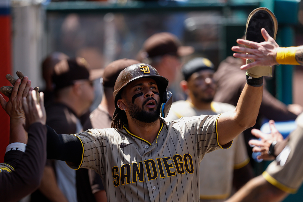 Diego Padres' Fernando Tatis Jr. is greeted by teammates after scoring during the fourth inning of a baseball game against the Los Angeles Angels, Sunday, April 19, 2026, in Anaheim, Calif. (AP Photo/Caroline Brehman)
