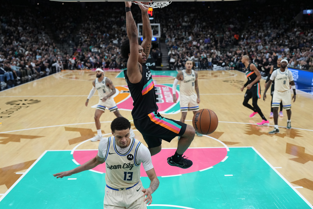 San Antonio Spurs guard Dylan Harper (2) scores over Milwaukee Bucks guard Ryan Rollins (13) during the second half of an NBA basketball game in San Antonio, Thursday, Jan. 15, 2026. (AP Photo/Eric Gay)