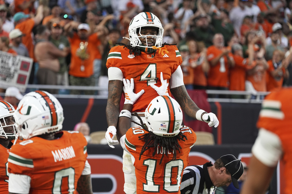 Miami running back Mark Fletcher Jr. (4) is lifted by wide receiver Malachi Toney after scoring a touchdown during the first half of an NCAA college football game against South Florida, Saturday, Sept. 13, 2025, in Miami Gardens, Fla. (AP Photo/Rebecca Blackwell)