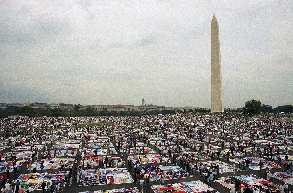 FILE — Thousands of people examine the individual panels of the AIDS quilt as it is displayed on the Mall in Washington on Oct. 11, 1992. (AP Photo/Stephen R. Brown, File)