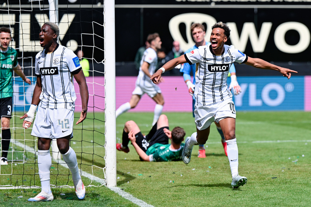 Elversberg's Bambase Conte, right, celebrates scoring their first goal of the game during the Bundesliga 2 soccer match between SV Elversberg and SC Preußen Münster in Spiesen-Elversberg, Germany, Sunday May 17, 2026. (Uwe Anspach/dpa via AP)