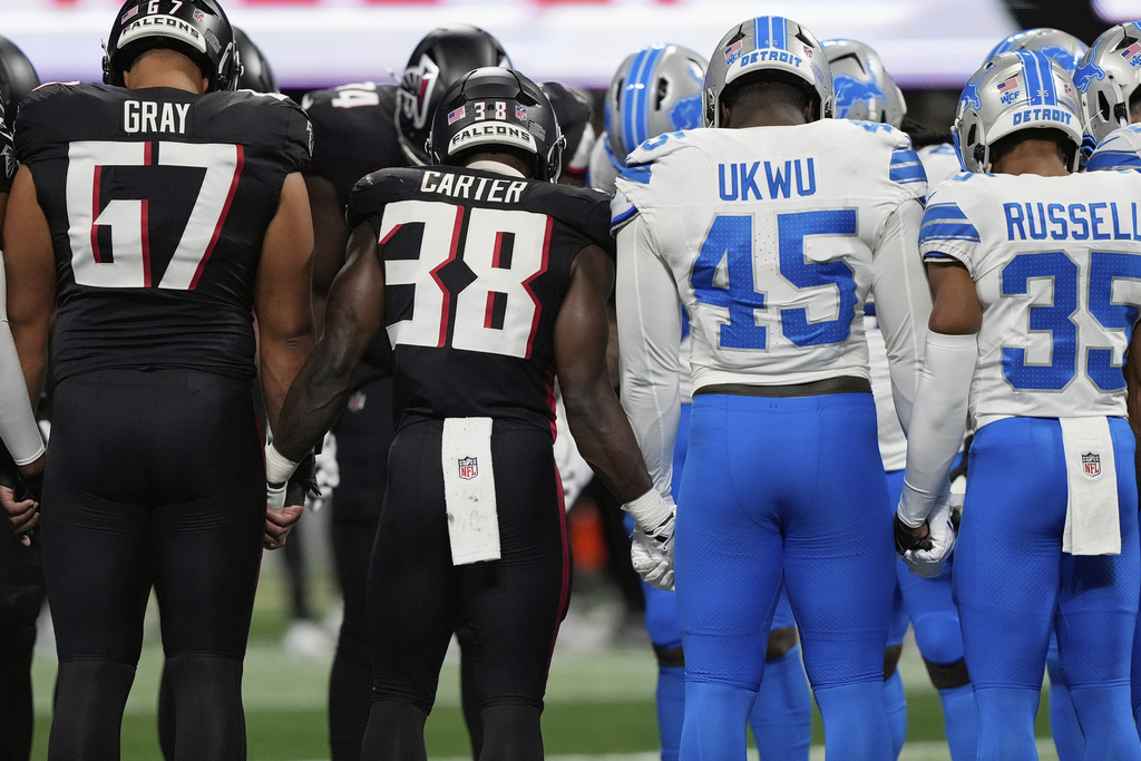 Atlanta Falcons and Detroit Lions players stand on the field hand in hand together after Detroit Lions safety Morice Norris was injured during the second half of an NFL preseason football game Friday, Aug. 8, 2025, in Atlanta. (AP Photo/Brynn Anderson)