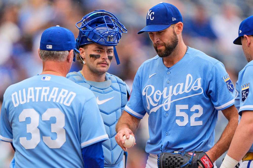Kansas City Royals starting pitcher Michael Wacha (52) hands the ball to manager Matt Quatraro (33) during a pitching change during the sixth inning of a baseball game against the Baltimore Orioles, Wednesday, April 22, 2026, in Kansas City, Mo. (AP Photo/Charlie Riedel)