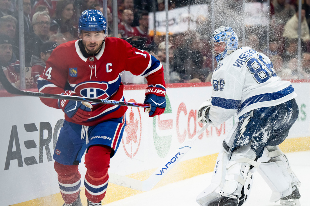 Montreal Canadiens' Nick Suzuki (14) skates towards the puck as Tampa Bay Lightning goaltender Andrei Vasilevskiy (88) clears the puck during the third period of an NHL hockey game, in Montreal, Thursday, April 9, 2026. (Christopher Katsarov/The Canadian Press via AP)