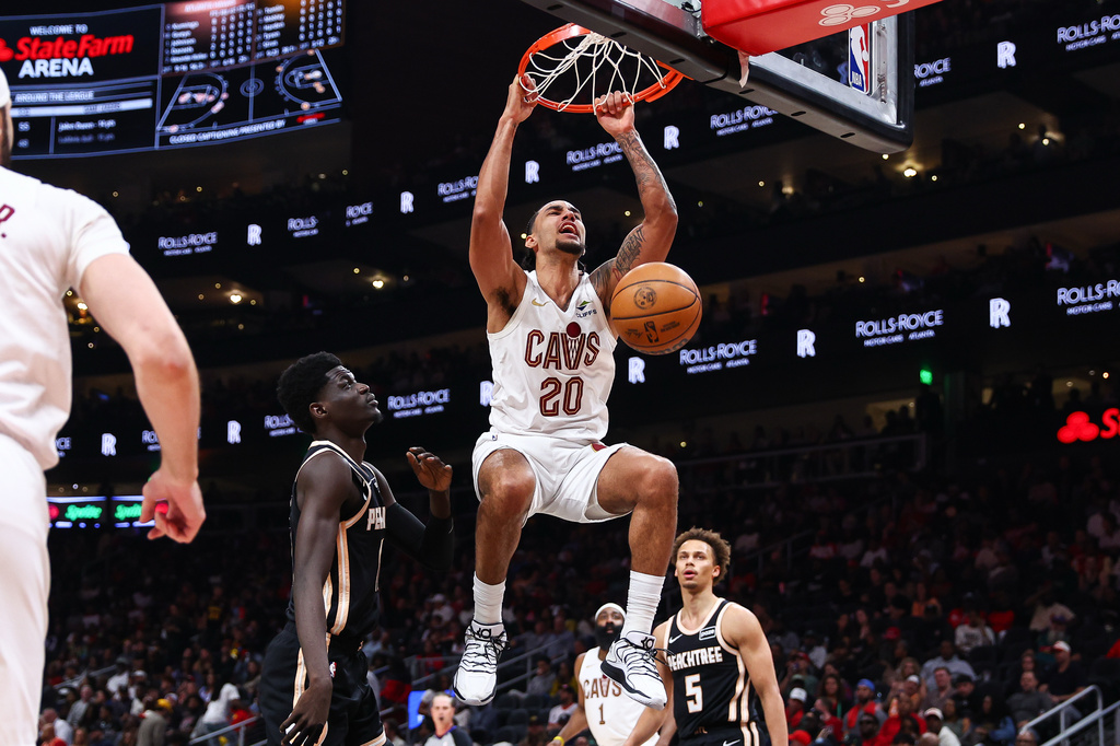 Cleveland Cavaliers guard Jaylon Tyson (20) dunks against Atlanta Hawks forward Mouhamed Gueye, center left, and guard Dyson Daniels (5) during the first half of an NBA basketball game, Friday, April 10, 2026, in Atlanta. (AP Photo/Colin Hubbard)