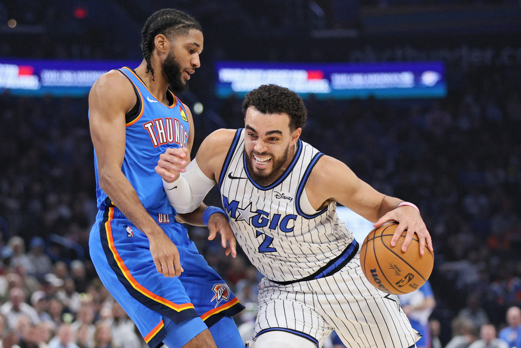 Orlando Magic guard Tyus Jones (2) drives against Oklahoma City Thunder guard Isaiah Joe, left, during the first half of an NBA basketball game, Tuesday, Feb. 3, 2026, in Oklahoma City. (AP Photo/Nate Billings)