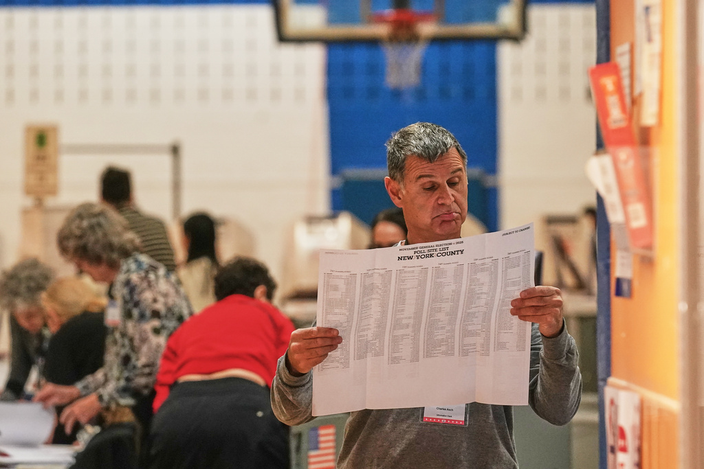 Workers prepare for voters at a poll site, in New York, Tuesday, Nov. 4, 2025. (AP Photo/Richard Drew)