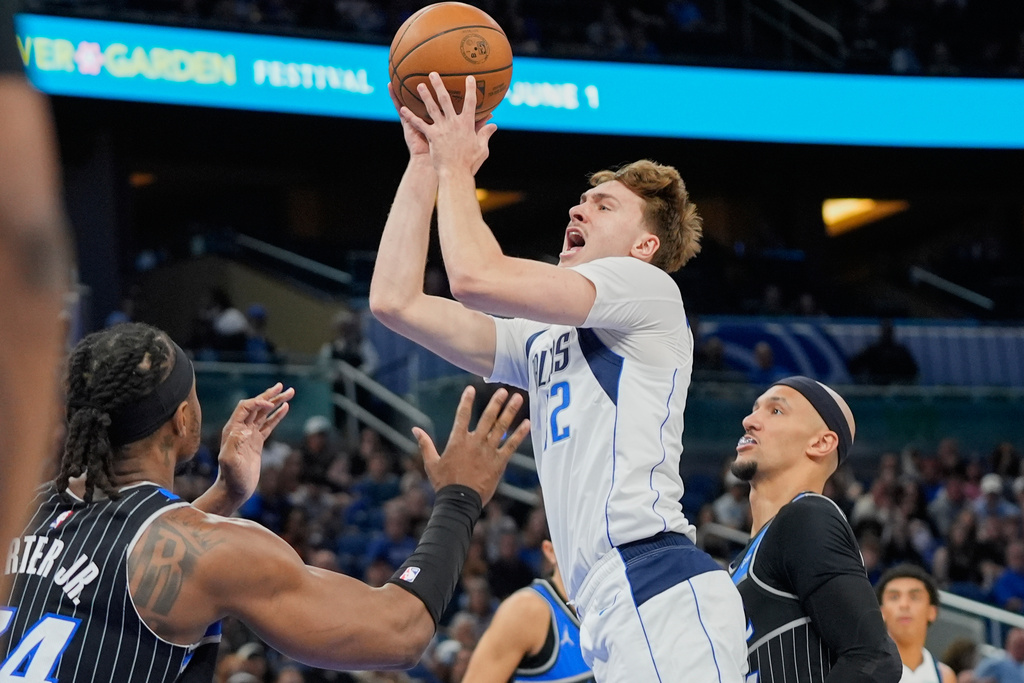 Dallas Mavericks forward Cooper Flagg, center, shoots over Orlando Magic center Wendell Carter Jr., left, and guard Jalen Suggs during the first half of an NBA basketball game, Thursday, March 5, 2026, in Orlando, Fla. (AP Photo/John Raoux)