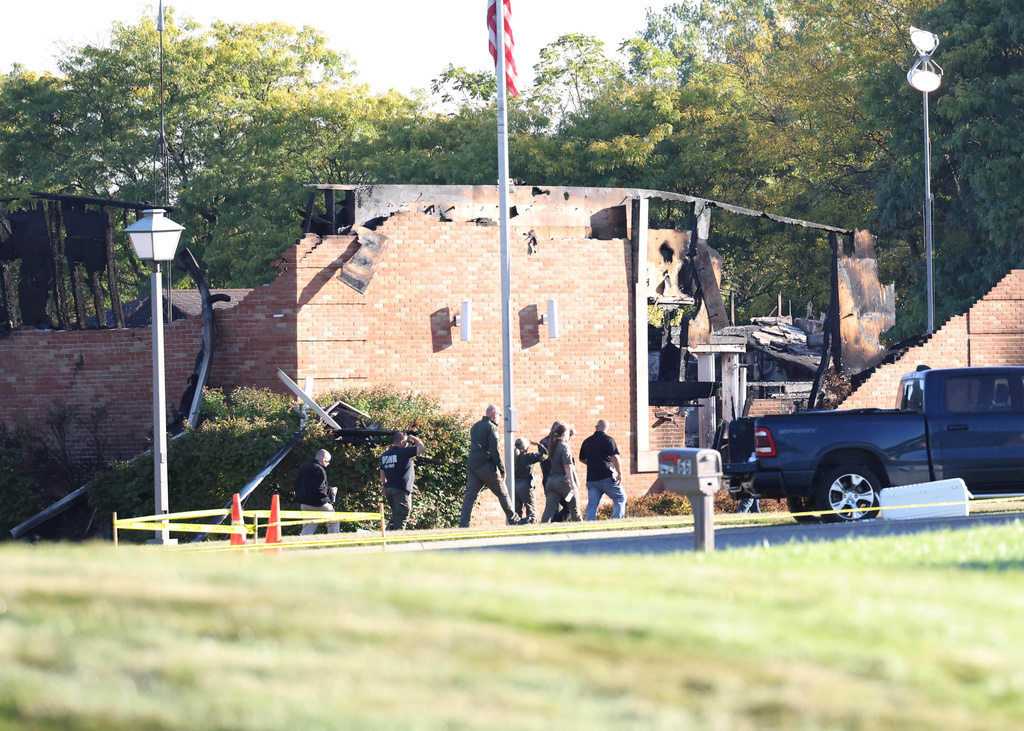 Law enforcement officers walk outside the Church of Jesus Christ of Latter-day Saints, Monday, Sept. 29, 2025 in Grand Blanc Township, Mich. (AP Photo/Carlos Osorio)