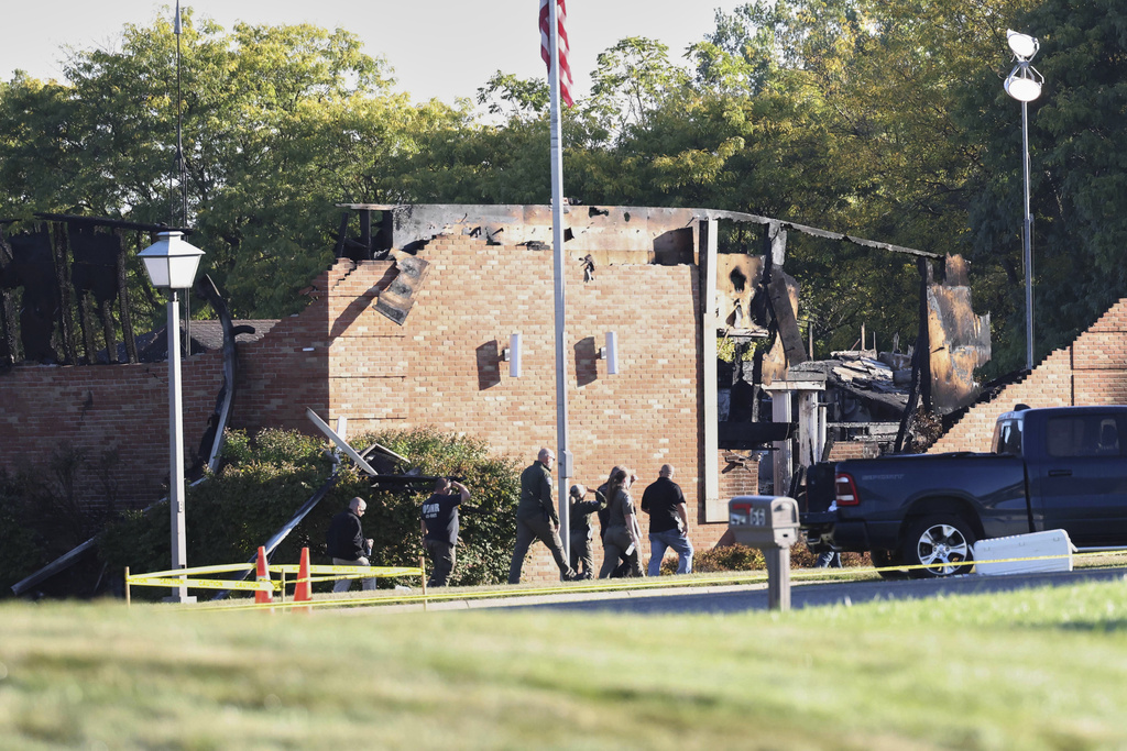 Law enforcement officers walk outside the Church of Jesus Christ of Latter-day Saints, Monday, Sept. 29, 2025, in Grand Blanc Township, Mich. (AP Photo/Carlos Osorio)