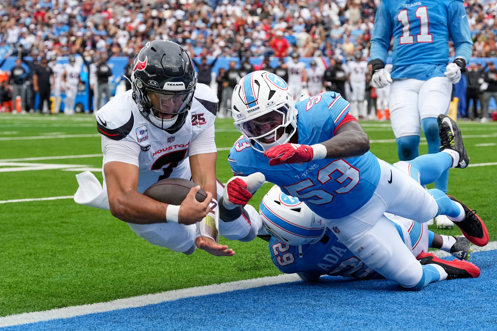 Houston Texans quarterback C.J. Stroud (7) dives into the end zone for a touchdown after running the ball past Tennessee Titans safety Tony Adams (29) and Anthony Hill Jr. (53) during the second half of an NFL football game in Nashville, Tenn., Sunday, Oct. 11, 2026. (AP Photo/George Walker IV)