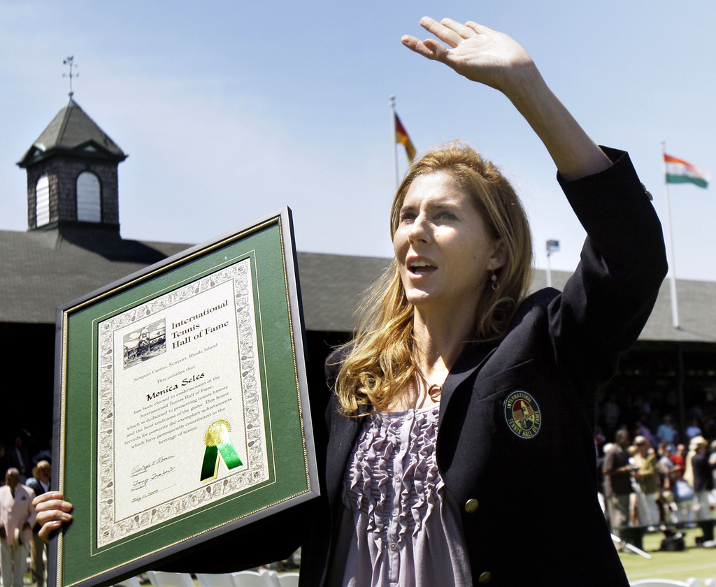 FILE - International Tennis Hall of Fame inductee Monica Seles waves to the crowd as she holds her plaque during ceremonies in Newport, R.I., July 11, 2009. (AP Photo/Elise Amendola, file)