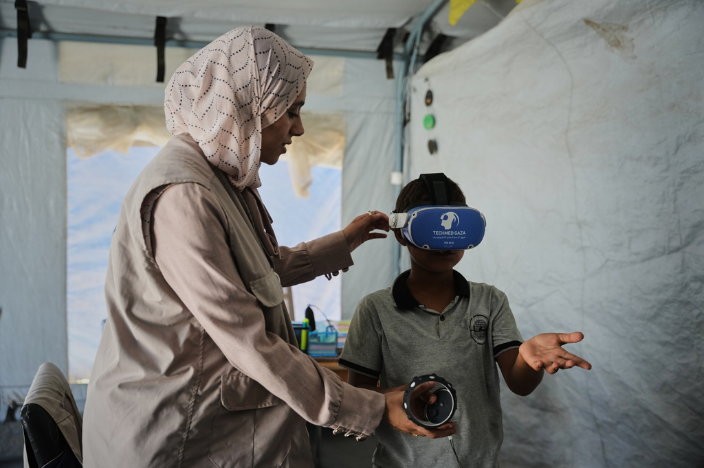 Ahmed Matar, 11, participates in a psychological support session using a virtual reality headset in a tent operated by a medical technology team in Zawaida, central Gaza Strip, Wednesday, June 17, 2026. (AP Photo/Abdel Kareem Hana)