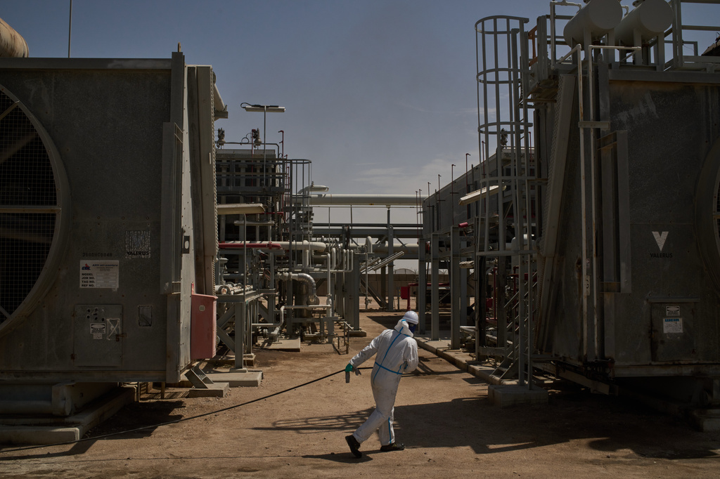 A worker pulls a hose as he works at a degassing station in Zubair oil field, whose operations have being reduced due to the Mideast war triggered by the U.S. and Israeli attacks on Iran, near Basra, Iraq, Saturday, March 28, 2026. (AP Photo/Leo Correa)