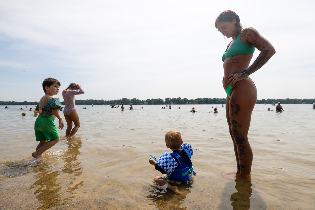 Lexis Aubile watches her son, Atticus, play in the water as they try to beat the heat at Ramona Park in Portage, Mich., on Tuesday, July 14, 2026. (Devin Anderson-Torrez/Kalamazoo Gazette via AP)