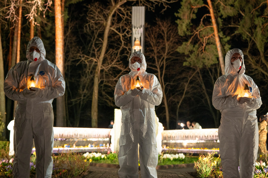 People dressed in white protective suits hold candles during a memorial service dedicated to firefighters and workers who died after the 1986 Chornobyl (Chernobyl) nuclear disaster, ahead of its 40th anniversary in Slavutych, Ukraine, Saturday, April 25, 2026. Chornobyl is the Ukrainian name for the city. (AP Photo/Dan Bashakov)