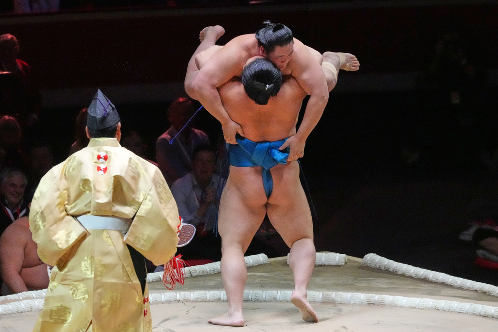 Kotoeiho, back to camera, pushes and lifts Oshoumi during their bout at The Grand Sumo Tournament at the Royal Albert Hall in London, Wednesday, Oct. 15, 2025.(AP Photo/Frank Augstein)